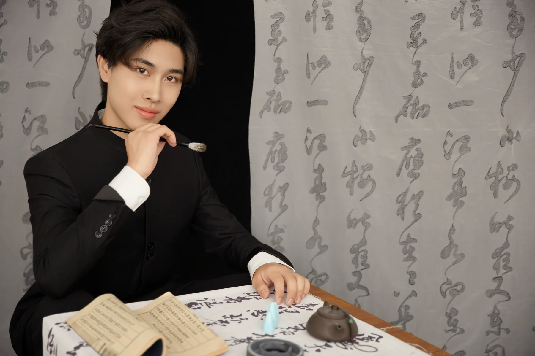 KSONG seated at a calligraphy table
